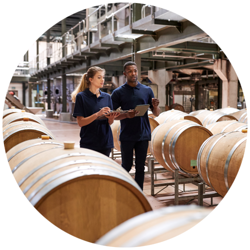 Circle with two employees walking among casks