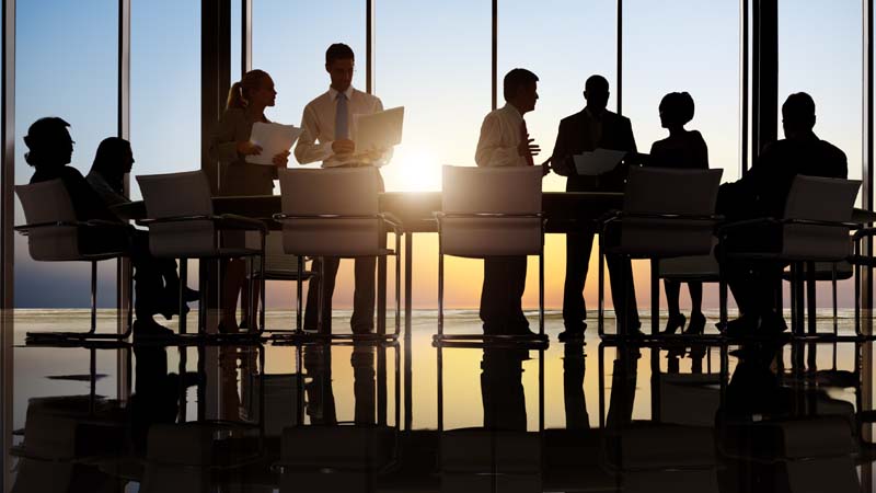 Silhouette of conference table with business professionals talking to each other