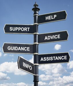 A pole with multiple street signs attached with the words help, support, advice, guidance, assistance, and info.