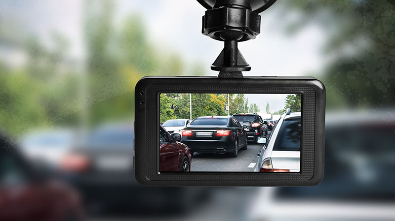 Modern dashboard camera mounted in car, view of road during driving