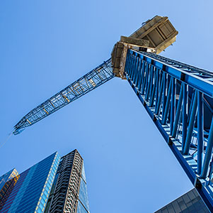 Crane construction on business building skyscraper facade